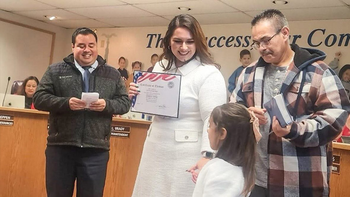 From left: San Ysidro School Board member Antonio Martinez, who administered the oath of office in Spanish, Cindy López, her daughter Darla and father Marco, holding the Bible she was sworn in on.